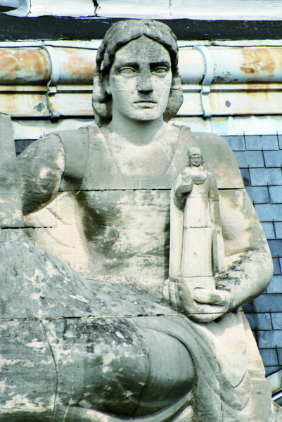 Une photo de l'ornementation extérieure qui représente une statue qui porte une autre statue dans sa main.