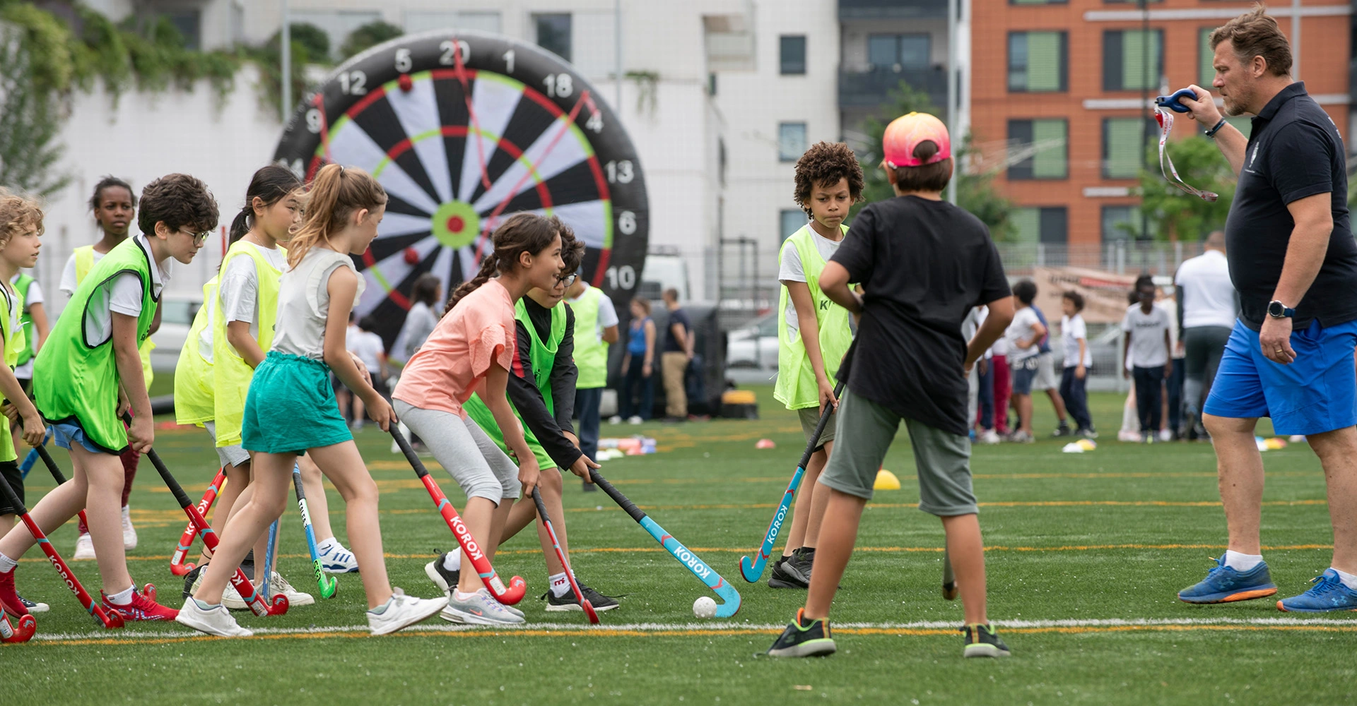 Photo décorative représentant des jeunes enfants jouant au hockey sur gazon.