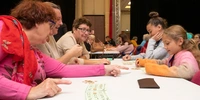 Visuel décoratif montrant des seniors jouant à une tabble avec des enfants.