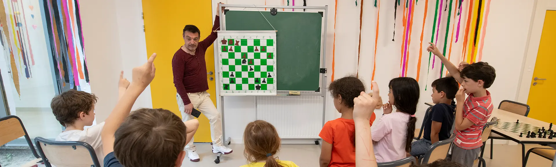 Visuel décoratif représentant des enfants participant à une activité périscolaire autour des échecs.
