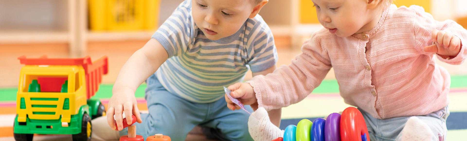 Visuel décoratif représentant de jeunes enfants jouant avec des jouets en bois.
