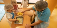 Visuel décoratif représentant des enfants recevant de la nourriture d'une personne adulte.