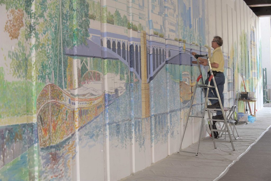 Une photo de l'artiste Hafiz Pakzad qui réalise la fresque du pont des Grésillons
