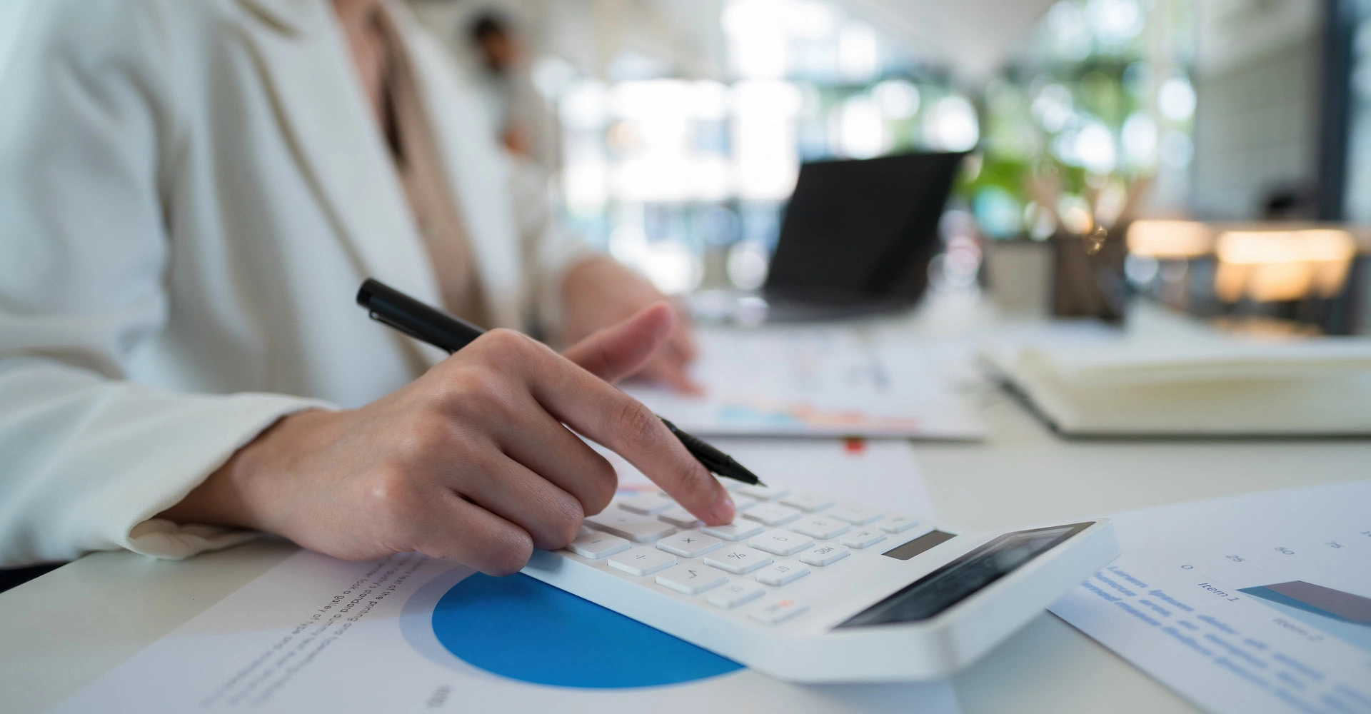 Visuel décoratif représentant une personne faisant des calculs sur une calculatrice.