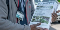 Visuel décoratif représentant une personne en train de tenir un paquet de magazines municipaux d'Asnières-sur-Seine.
