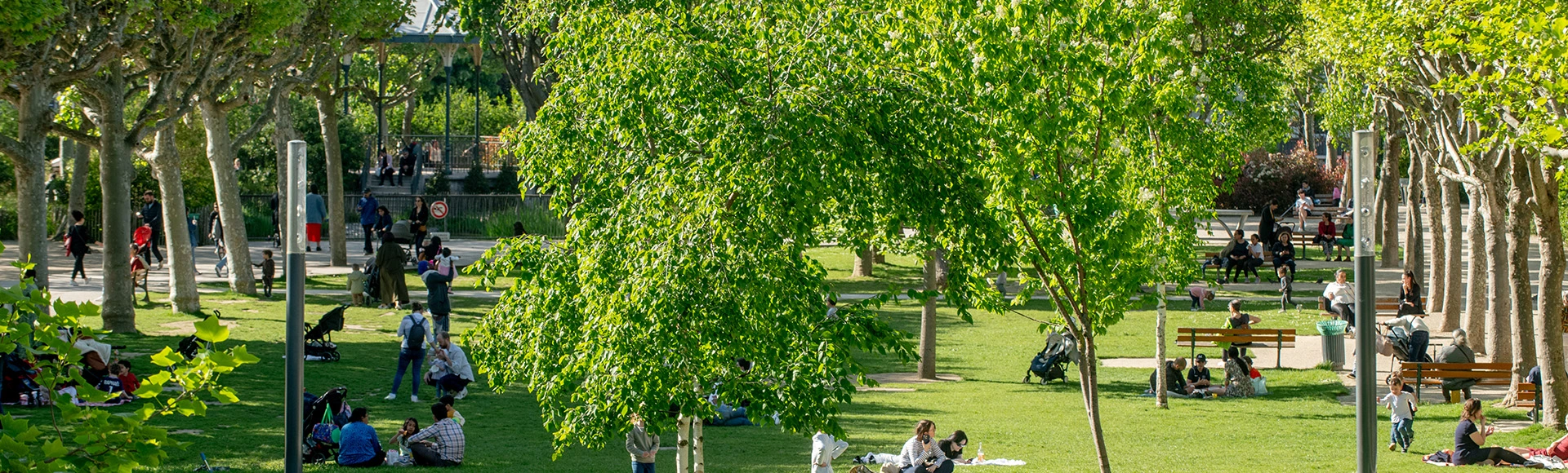 Visuel décoratif représentant des personnes assises dans l'herbe au soleil dans un parc de la ville d'Asnières.
