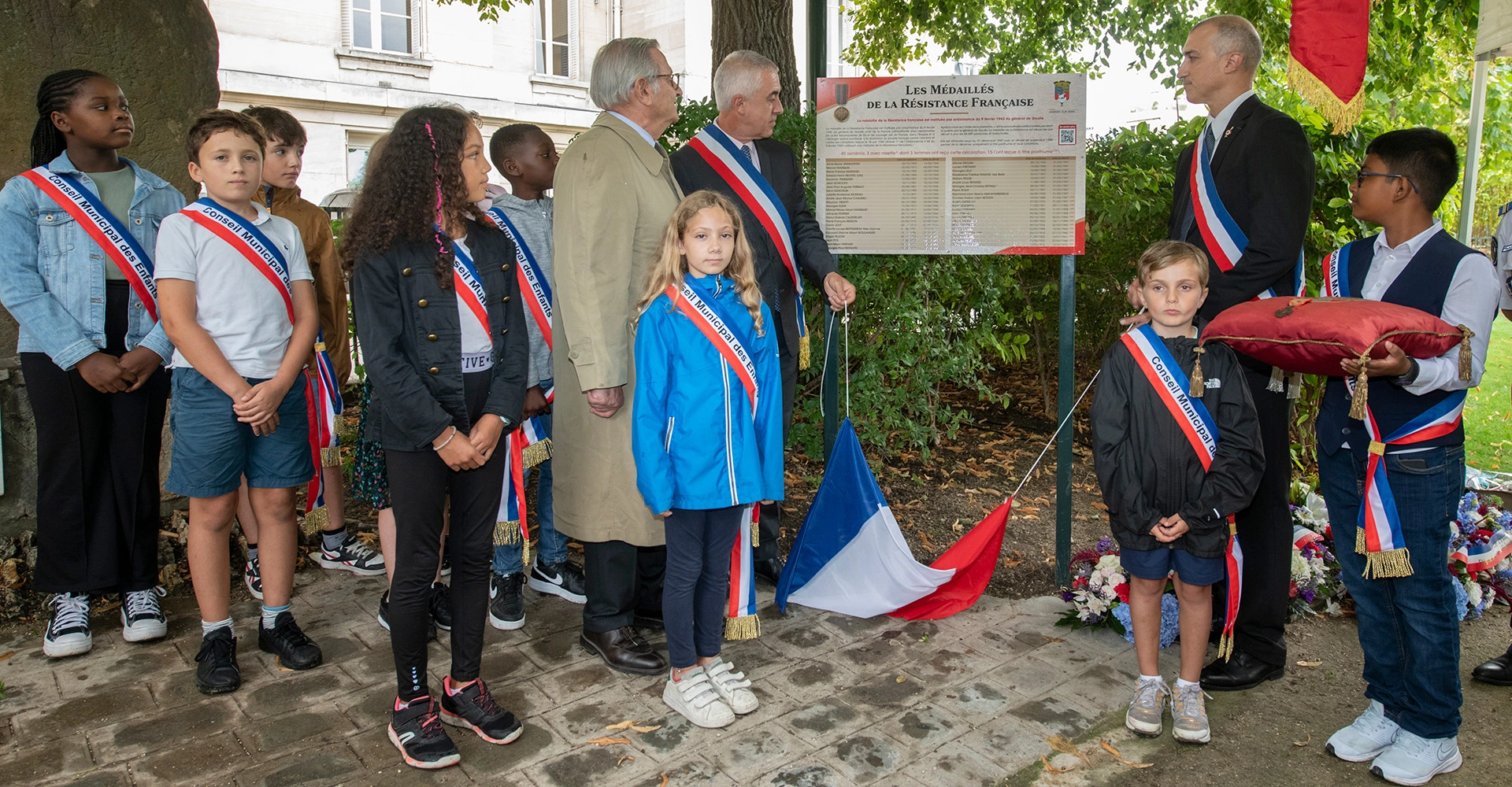 Visuel décoratif représentant une scène de commémoration à Asnières-sur-Seine avec Mr le Maire, l'adjoint aux commémorations et des enfants du conseil municipal des enfants.