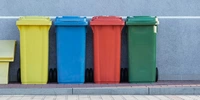 Visuel décoratif représentant des bennes à ordures de plusieurs couleurs.