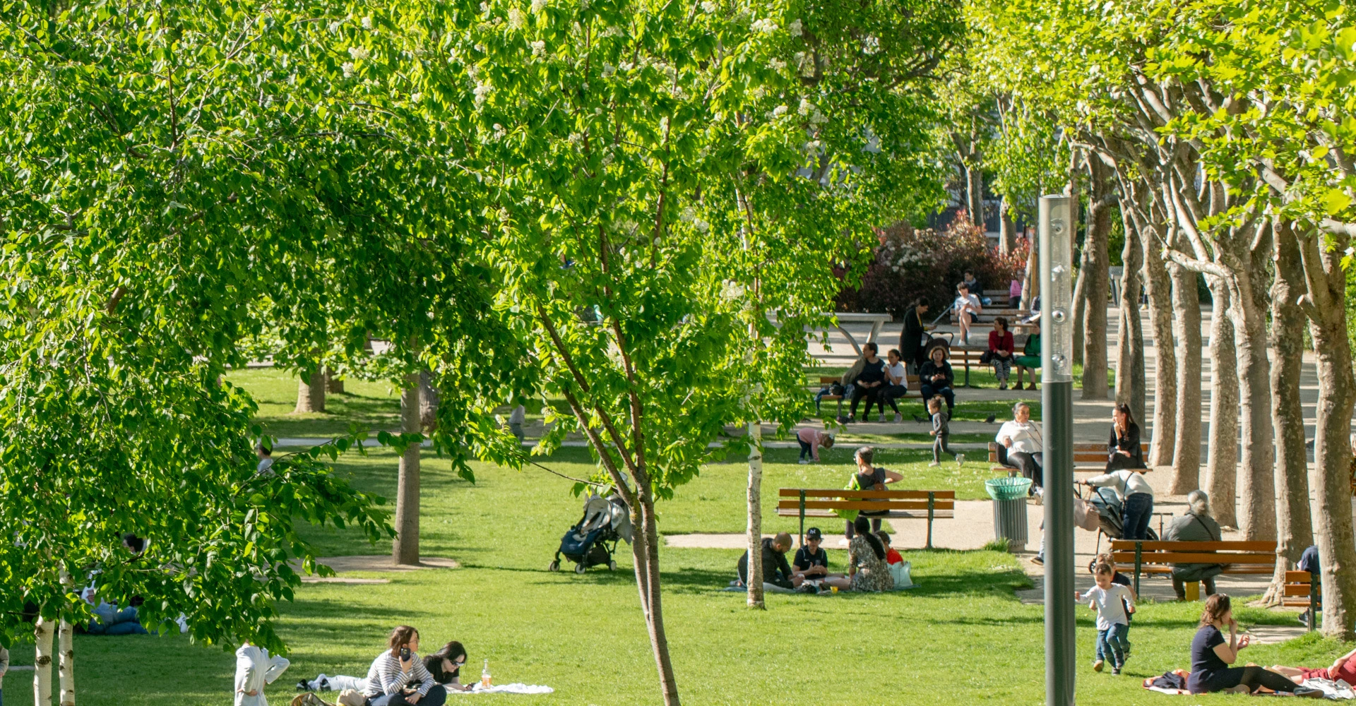 Visuel décoratif représentant des personnes assises dans l'herbe au soleil dans un parc de la ville d'Asnières.