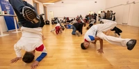 Visuel décoratif représentant des jeunes en train de faire du brek-danse tandis que d'autres regardent.