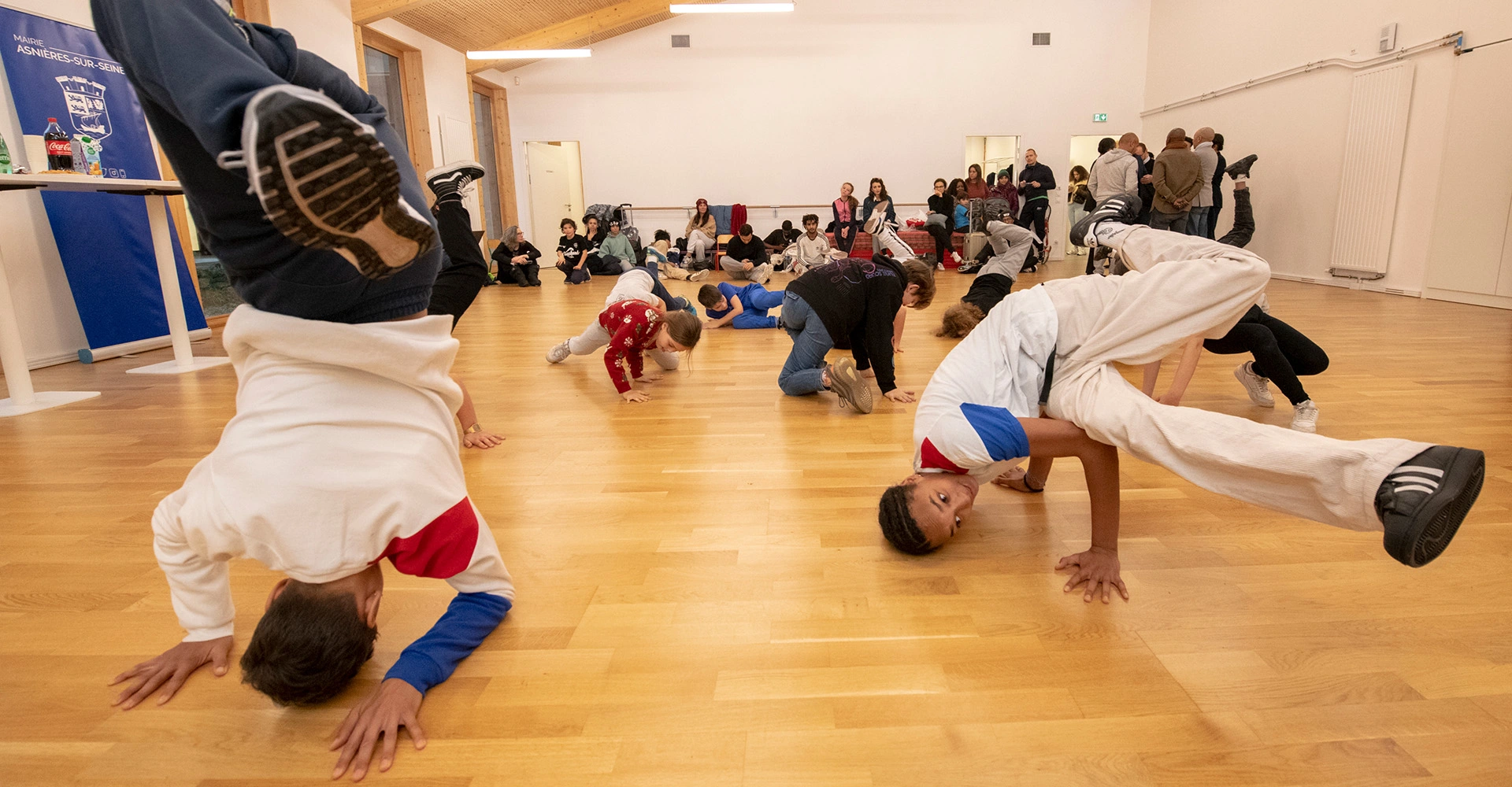 Visuel décoratif représentant des jeunes en train de faire du brek-danse tandis que d'autres regardent.