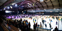 Une photo prise à l'intérieur de la patinoire de Courtilles ou l'on peut voir des adultes et des enfants patiner 