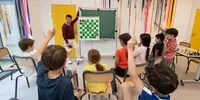 Visuel décoratif représentant des enfants participant à une activité périscolaire autour des échecs.