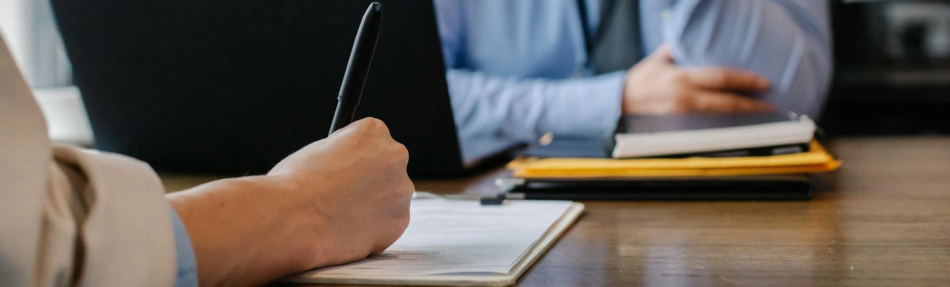 Visuel décoratif représentant deux personnes en entretien, assis à une table en face l'un de l'autre.