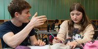 Visuel décoratif représentant une personne accompagnant un élève en soutien scolaire.