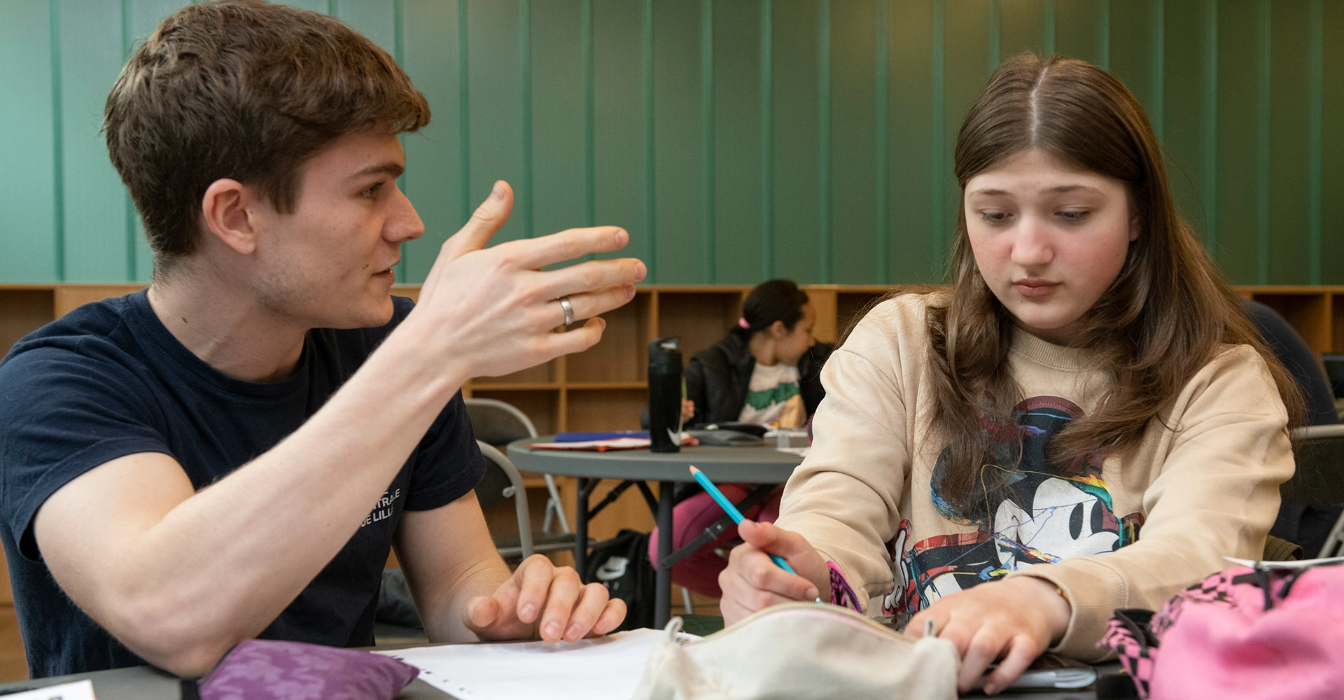 Visuel décoratif représentant une personne accompagnant un élève en soutien scolaire.